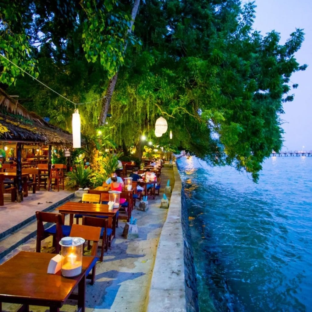 Tables en bord de mer au Nikita's Beach Restaurant à Phuket, Thaïlande, offrant un cadre romantique avec vue sur l'eau et une ambiance tropicale